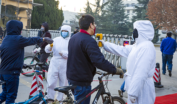 06 北門執勤人員配合醫務人員為職工測體溫。.jpg