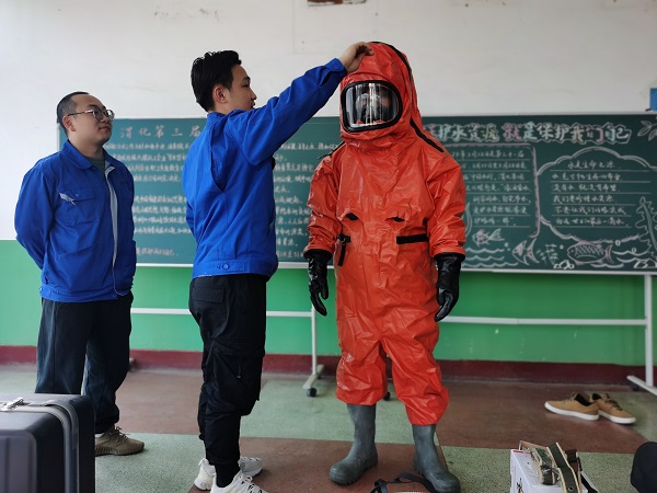 3月31日，應急隊員張晨、于堯對重型防化服的使用進行講解.jpg