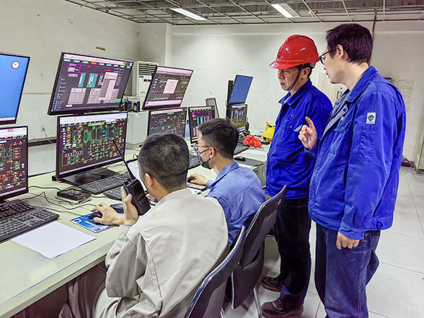 5月13日，動力車間三期鍋爐控制室，DCS改造工藝、儀表、電氣等部門聯合調試，車間主任姜軍虎與技術員畢加佳查看調試過程.jpg