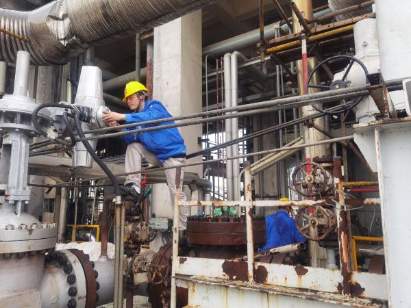 氣化爐上，柳曦、徐騰飛冒雨調試氣化爐電動閥.jpg
