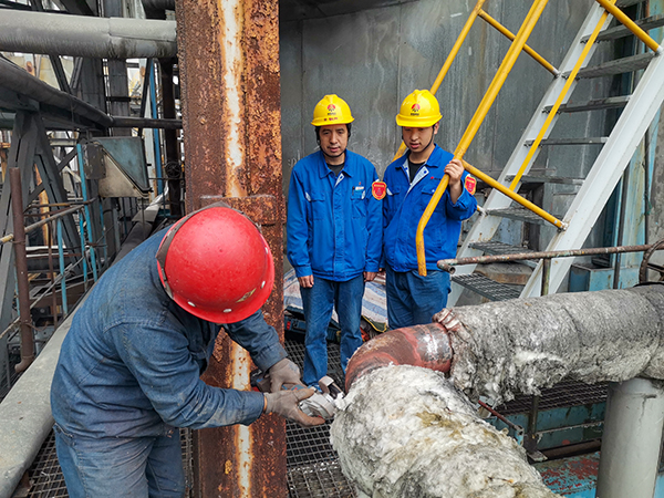 10月17日下午，在1號鍋爐暖風器S2管道檢測處，安朝陽和張跟潮在監護外協人員工作.jpg