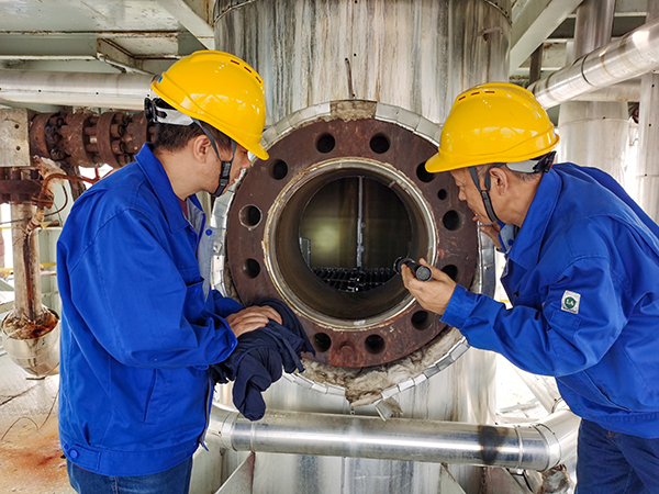 尿素車間曾迎軍、李廣志檢查高壓洗滌器內部是否有腐蝕情況.jpg