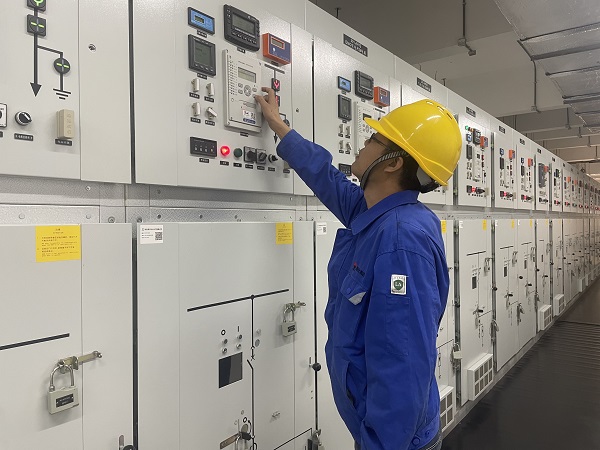 電儀分部工段長馮向陽在配電室內查看設備運行數據.jpg