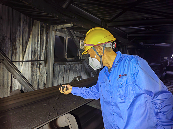 151755234968133333.jpg 8月14日晚,動力車間運行一班班長閆海斌在原料上煤皮帶處查看燃煤情況 (1).jpg